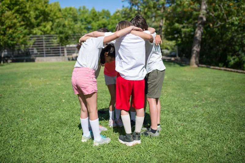 Kinderen in een teamhuddle op het sportveld