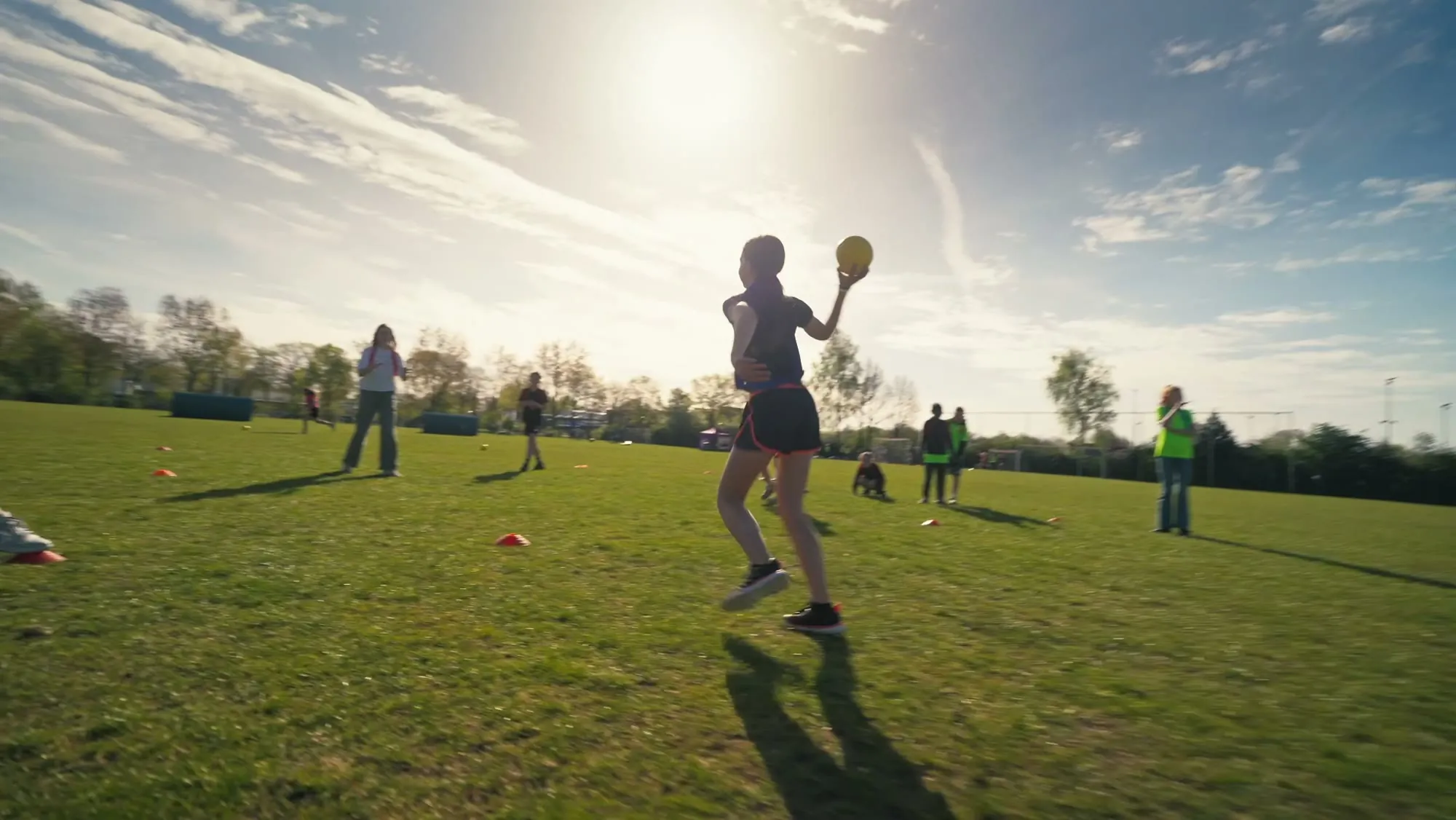 Leerling gooit een dodgeball in de zon